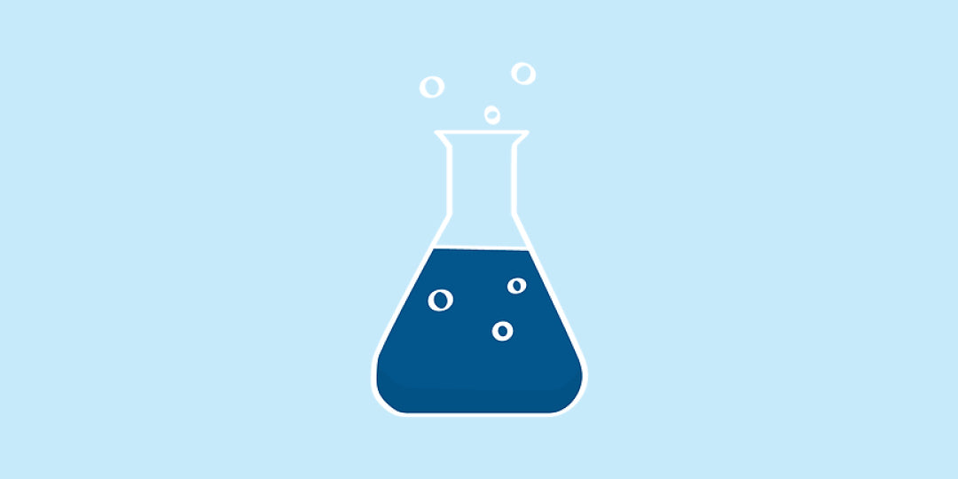 A conical flask with blue liquid in it and bubbles inside and over the flask