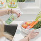 A lady spraying Nellie's Fruit and Veggie Wash on a Bowl full of Veggies and Fruits
