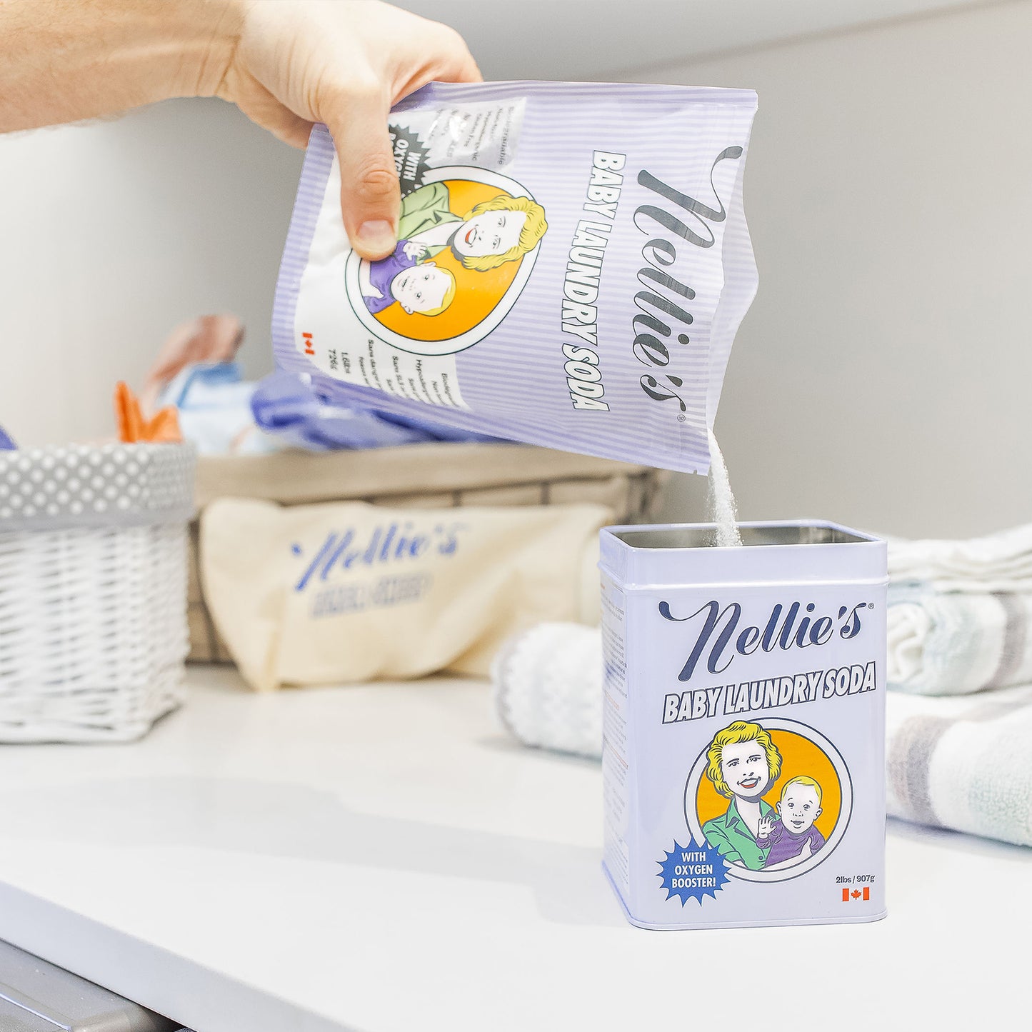 A male hand pouring Nellie's Baby Laundry Soda from it's Refill pack into the Tin